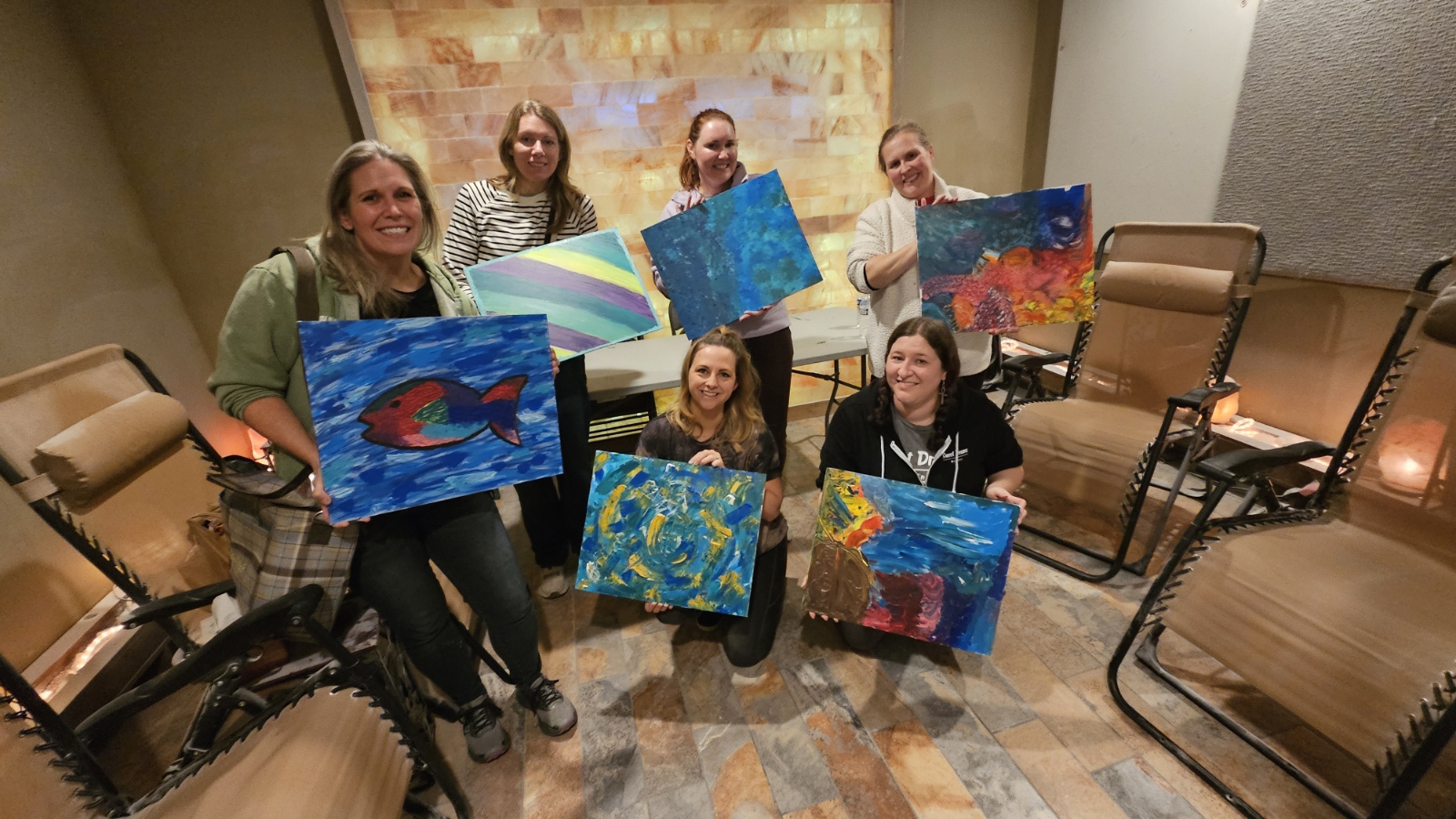 A group holding their artwork during a gathering at Sweet Dreams