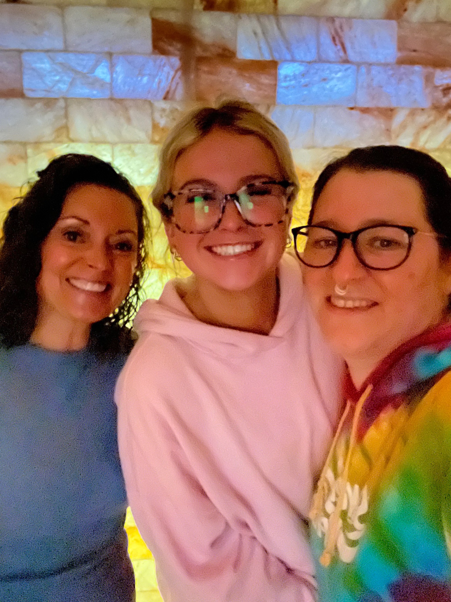 Three people gathered in front of the illuminated salt wall